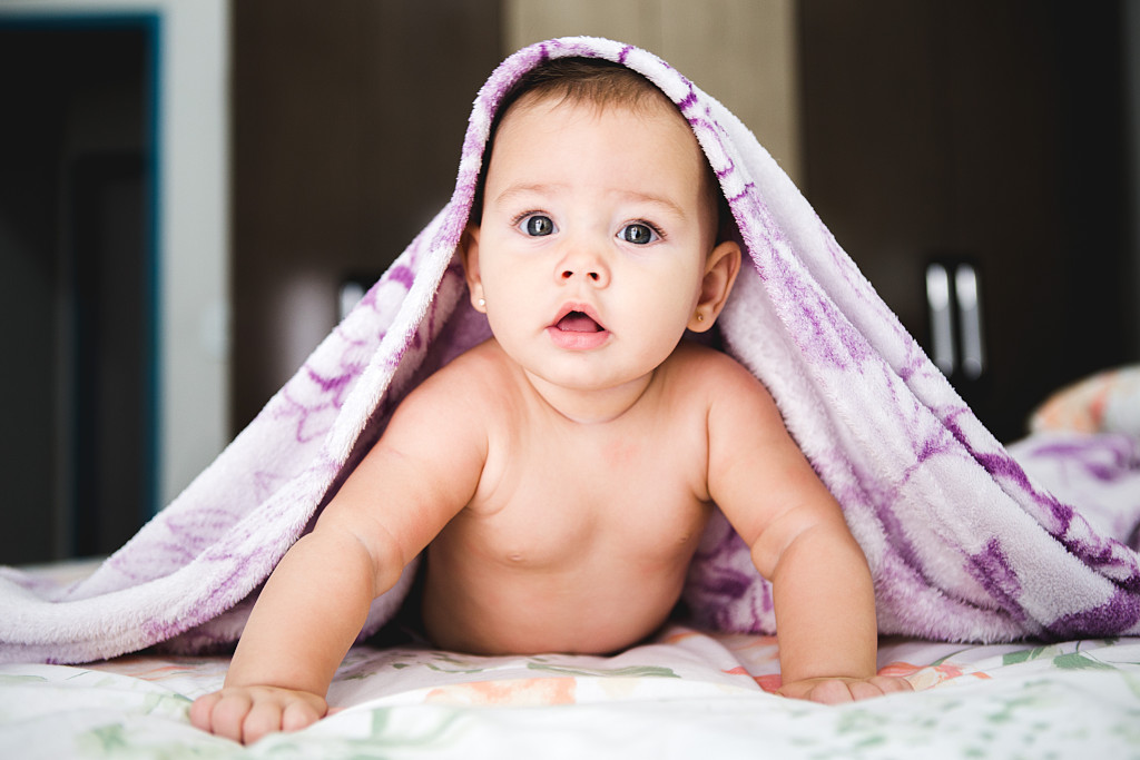 Bebé de frente con toalla encima
